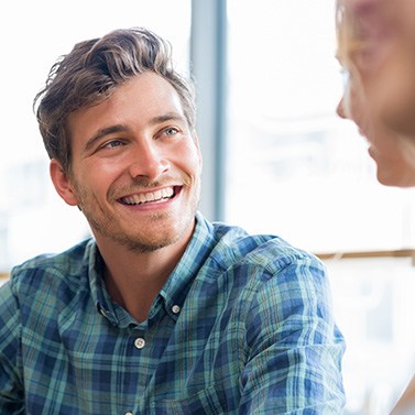 Man in blue shirt smiling at friend