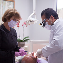 Dentist and dentistry team member treating dental patient