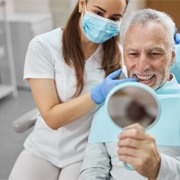 a patient checking his dentures in West Palm Beach