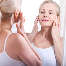 Older woman with dentures looking in mirror