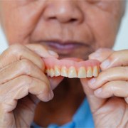 a person holding their denture in West Palm Beach