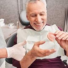 A dentist showing high-quality dentures to a patient