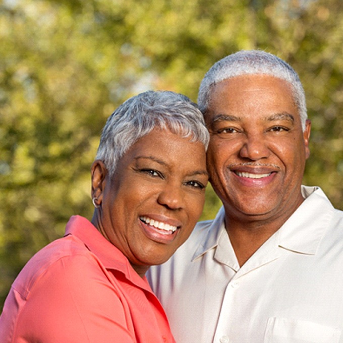 smiling senior man and woman with implant dentures in West Palm Beach, FL