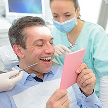 Patient examining their dental implants in West Palm Beach