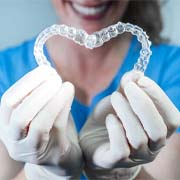 dentist holding Invisalign trays in a heart shape