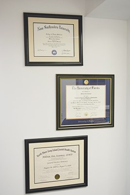 Dentist degrees hanging on wall