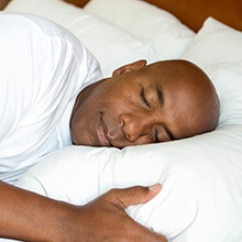 Man sleeping soundly in bed thanks to nightguard for teeth grinding and clenching