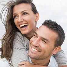 Young happy couple with porcelain veneers smiling brightly