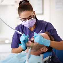 a dental hygienist cleaning a patient’s teeth
