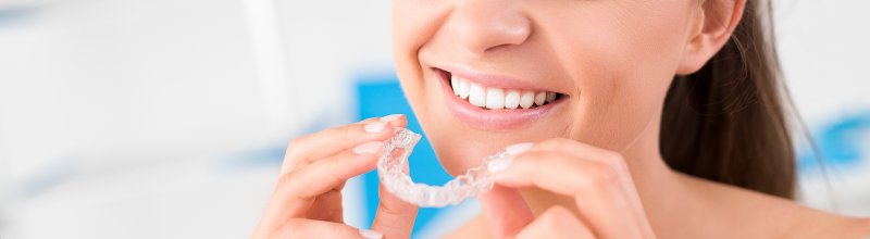 attractive young woman inserting invisalign