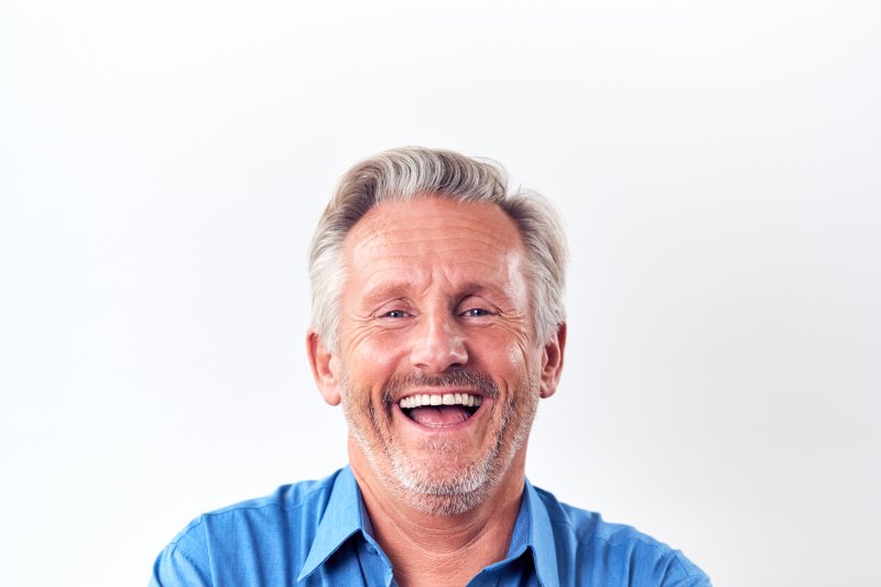 mature man laughing with implant dentures in West Palm Beach