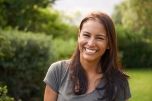 Woman with brown hair outside smiling