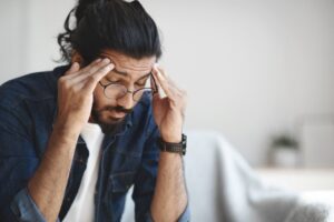 Man rubbing temples (headache). 